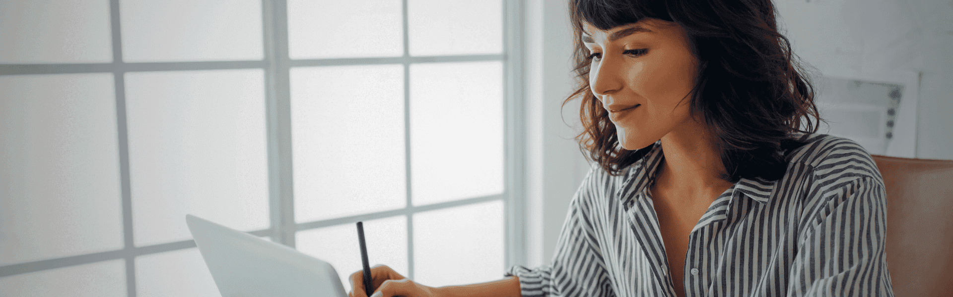 Frau mit Bluse sitzt am Schreibtisch