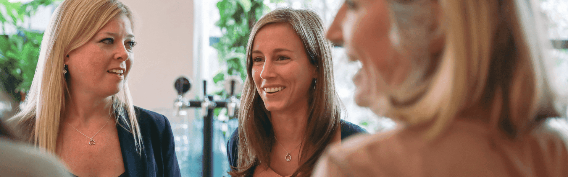 Zwei Frauen stehen beiander und unterhalten sich im Büro.