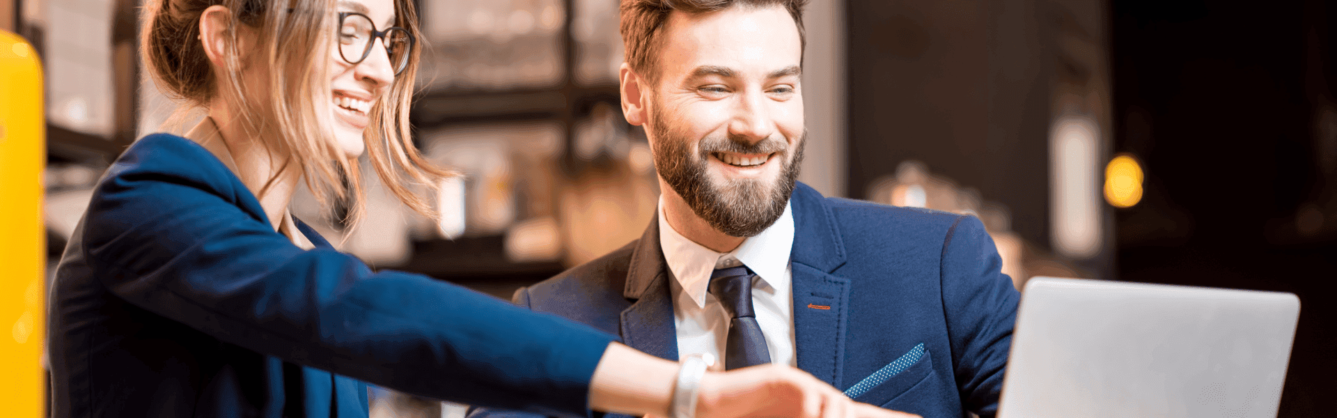 Zwei Kollegen zeigen auf einen Bildschirm